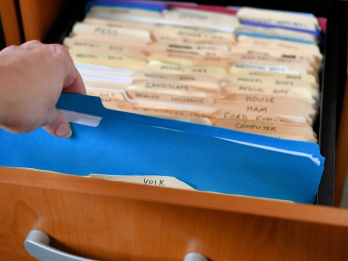 Hand reaching into a cabinet for file