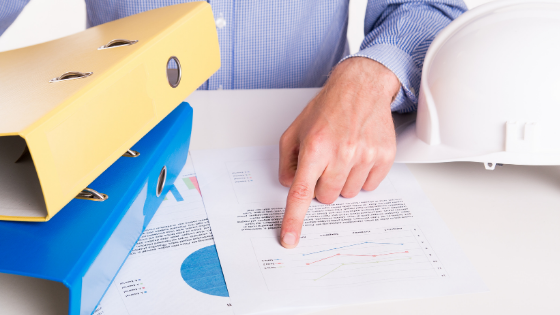 man pointing at reports on desk
