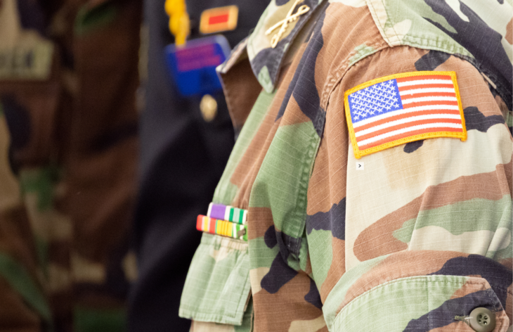 Veteran in an army uniform with an american flag.