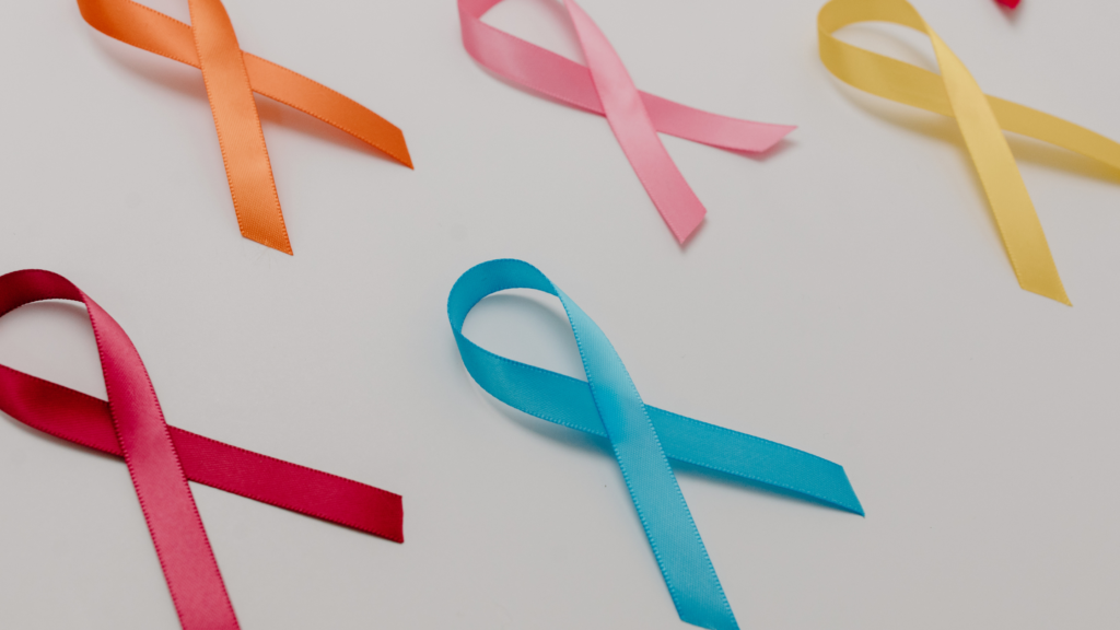 Bright colored ribbons on a white background signify cancer survivors.