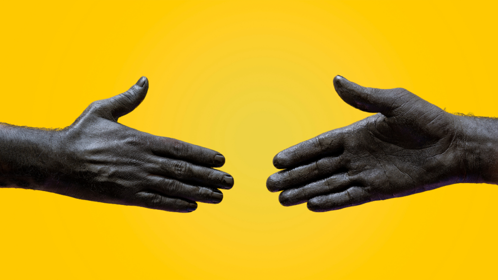 two hands shaking on a yellow background