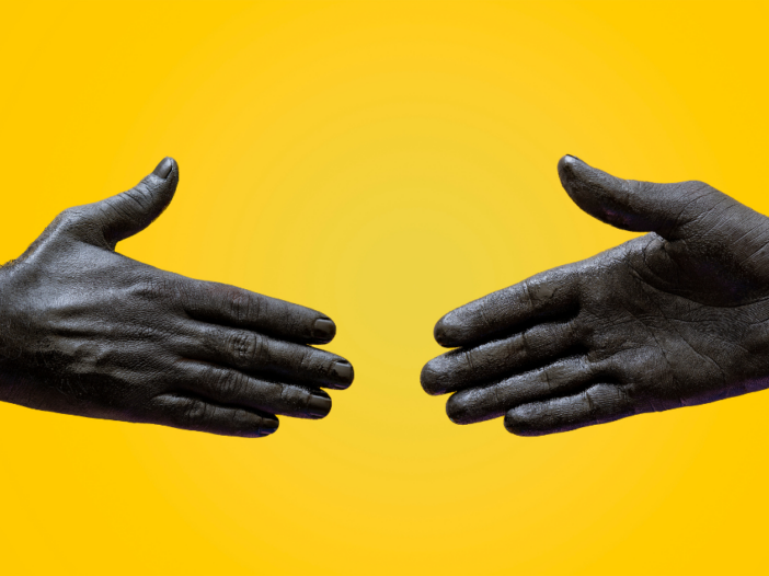 two hands shaking on a yellow background