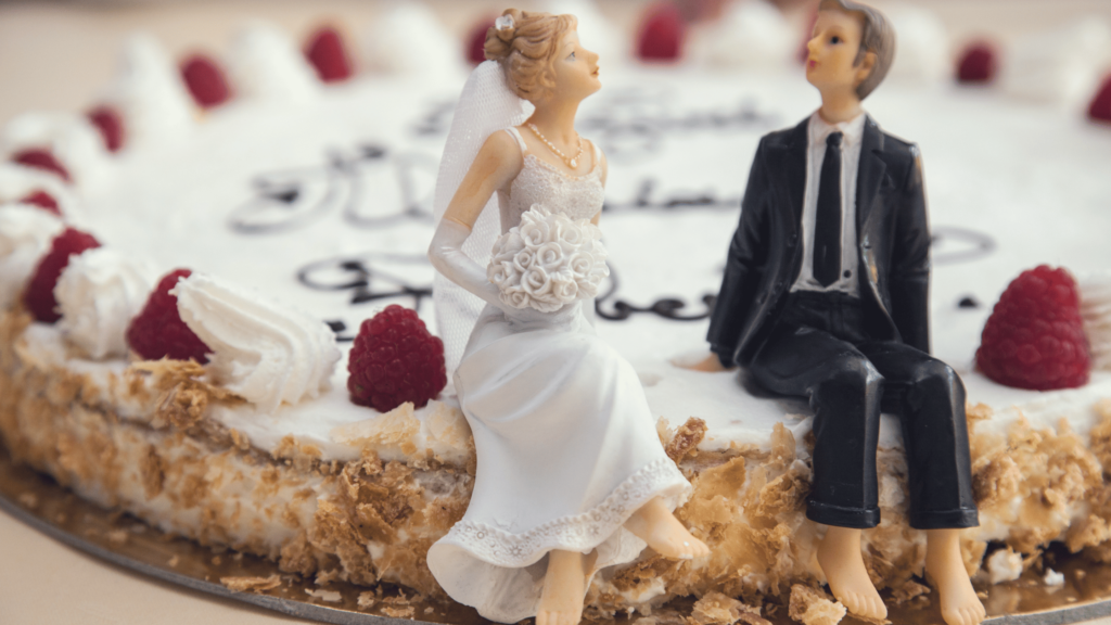 Bride and Groom doll sitting on a wedding cake.