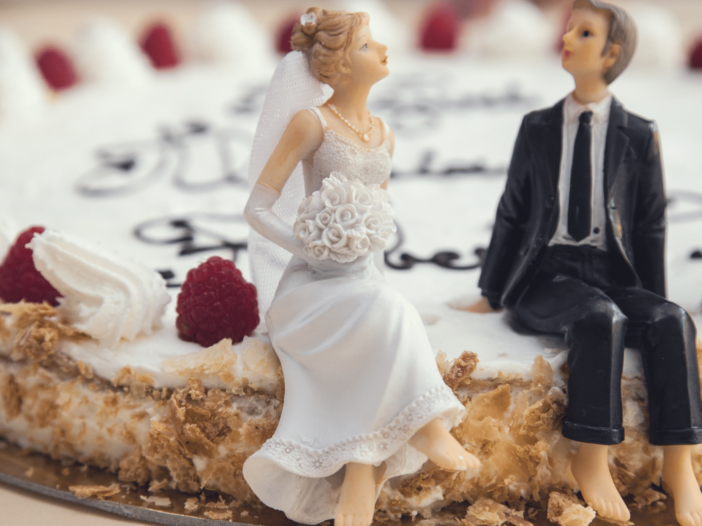 Bride and Groom doll sitting on a wedding cake.