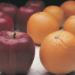 apples and oranges sitting on a table