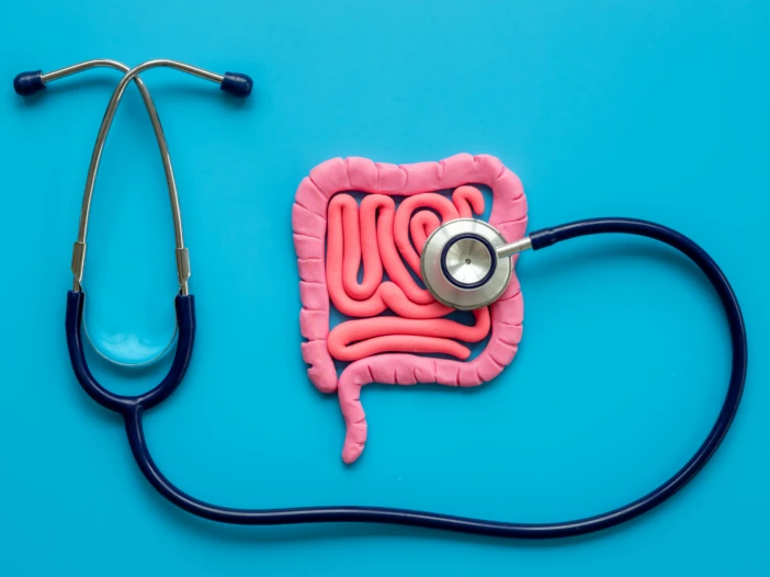 A picture of a colon with a stethoscope on a blue background.
