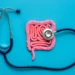 A picture of a colon with a stethoscope on a blue background.