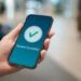Hand holding a phone with 'payment successful' icon. Title of blog post is "How Much Does SSDI Pay in North Carolina? (Winston-Salem Guide)