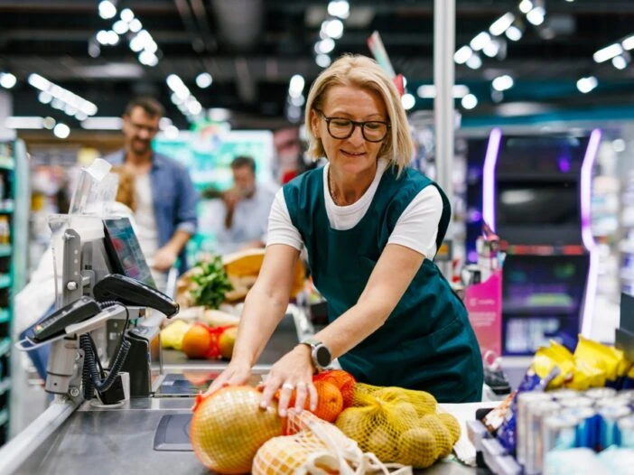 Female grocery store clerk scanning fruit