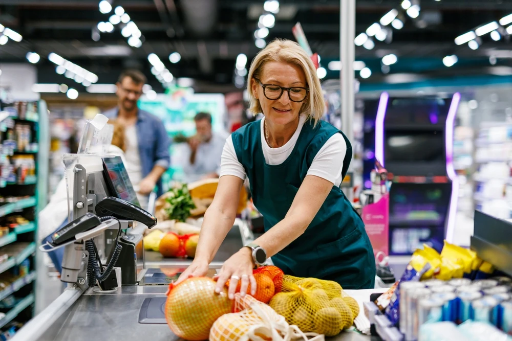 Female grocery store clerk scanning fruit