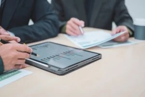 Photo of a lawyer meeting with clients in a professional office, offering expert legal consultation and representation. Photo accompanies a blog post titled: "What Is a Vocational Expert at a Social Security Disability Hearing in North Carolina?"