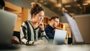 Header image showing a woman working at a computer accompanying a blog post titled - "What Is Substantial Gainful Activity in a North Carolina Disability Claim?"