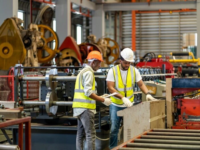 Image of two men in safety vests working in a factory which is the header image for a blog post titled: "What Is an Unsuccessful Work Attempt in a North Carolina Disability Claim?"