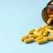 A picture of pills spilling out from an amber bottle onto a blue background which is the header image for a blog post titled: How Medication Side Effects Can Affect a Social Security Disability Claim in North Carolina