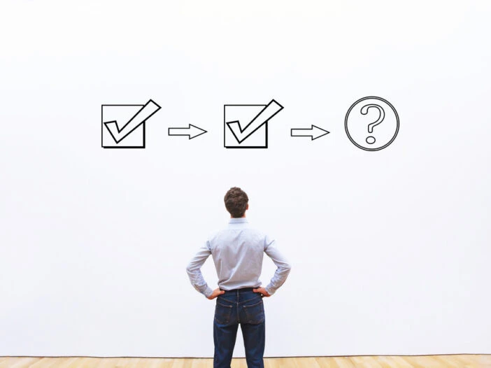 A business man staring at a white board with two checkmarks and a third step marked with a question mark. This is the header image accompanying a blog post titled - What Happens After a Trial Work Period for Social Security Disability in North Carolina?